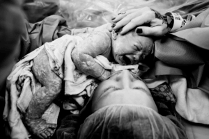 Newborn baby skin being held by mother at birth