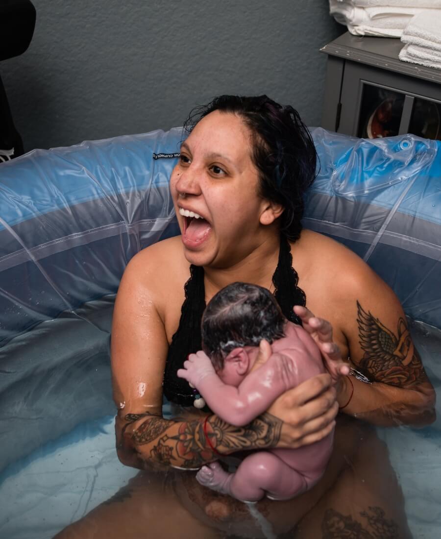 Mother holding her newborn baby moments after a water birth