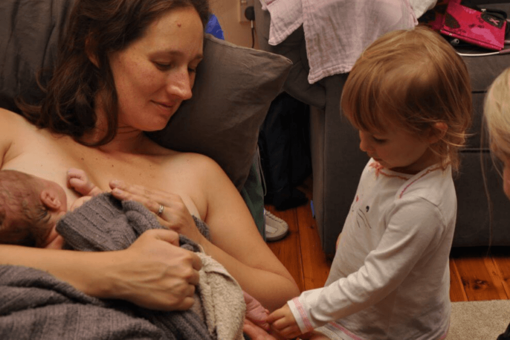 Sibling meeting their new baby after a homebirth